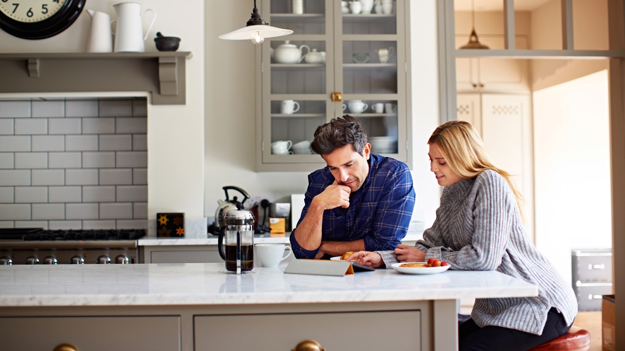 Couple using digital tablet in the kitchen