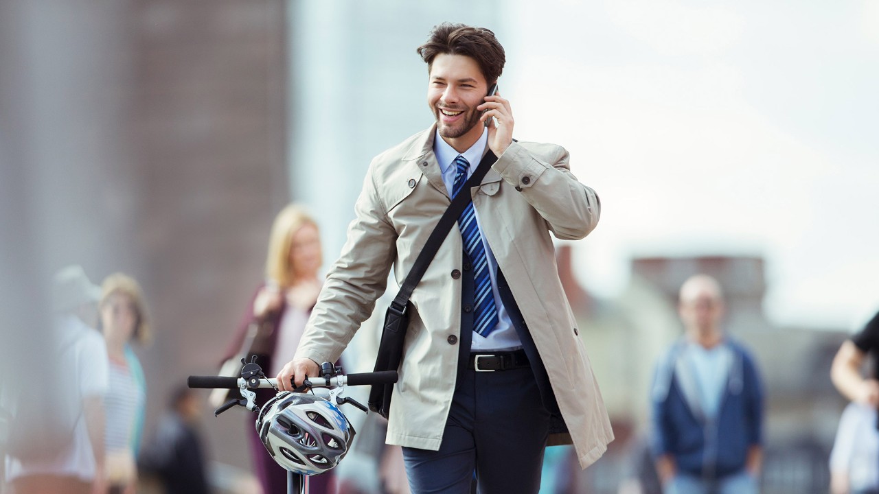 Businessman walking on the bridge using phone